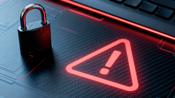 Un zoom sur le trackpad d'un ordinateur portable sur lequel se trouve un cadenas et s'affiche en rouge le triangle qui représenter le danger.